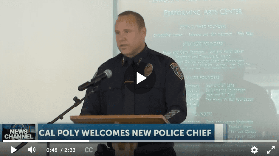 Police chief speaking at podium during Cal Poly welcome event, news banner reads "Cal Poly welcomes new police chief.