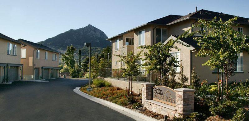 Residential townhouses with a "Villa Montana" sign and a mountain in the background.