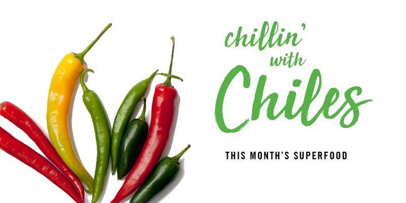 Seven assorted red, yellow, and green chili peppers with text "chillin' with Chiles This Month's Superfood" on white background.