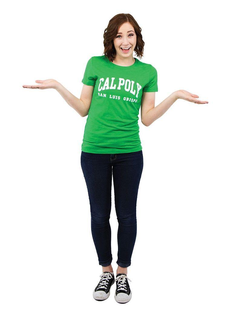 Woman smiling wearing a green "CAL POLY San Luis Obispo" shirt, black jeans, and sneakers, with arms extended outward.