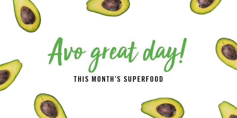 Avocado halves with text "Avo great day! This month's superfood" on white background.