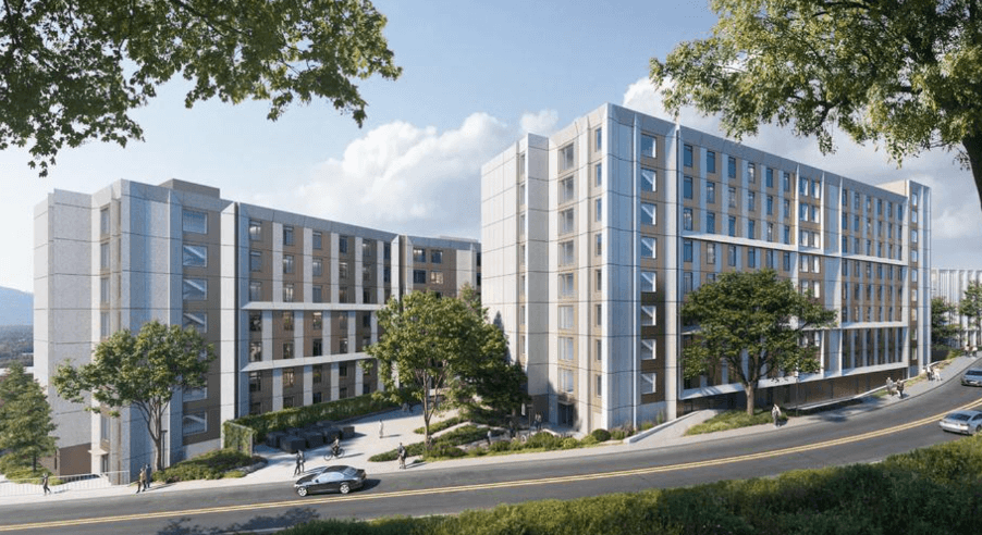Modern mid-rise apartment buildings with large windows and surrounding trees along a curved road.
