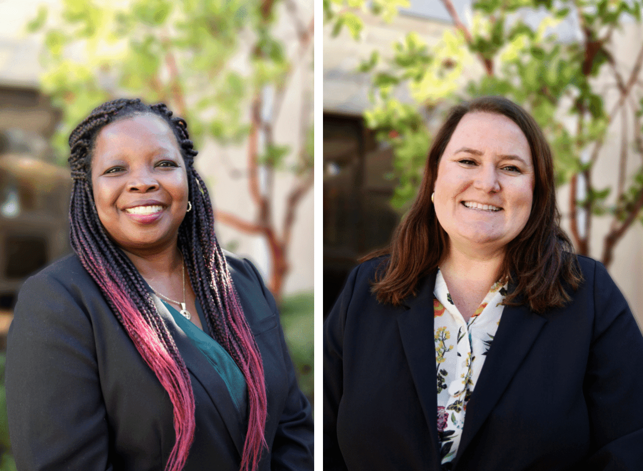 Two women smiling outdoors, both wearing dark blazers; one has pink-tipped braids, the other has shoulder-length brown hair.